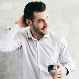 Brickell pomade in hand demonstrating compact 2 oz scale and travel-friendly convenience