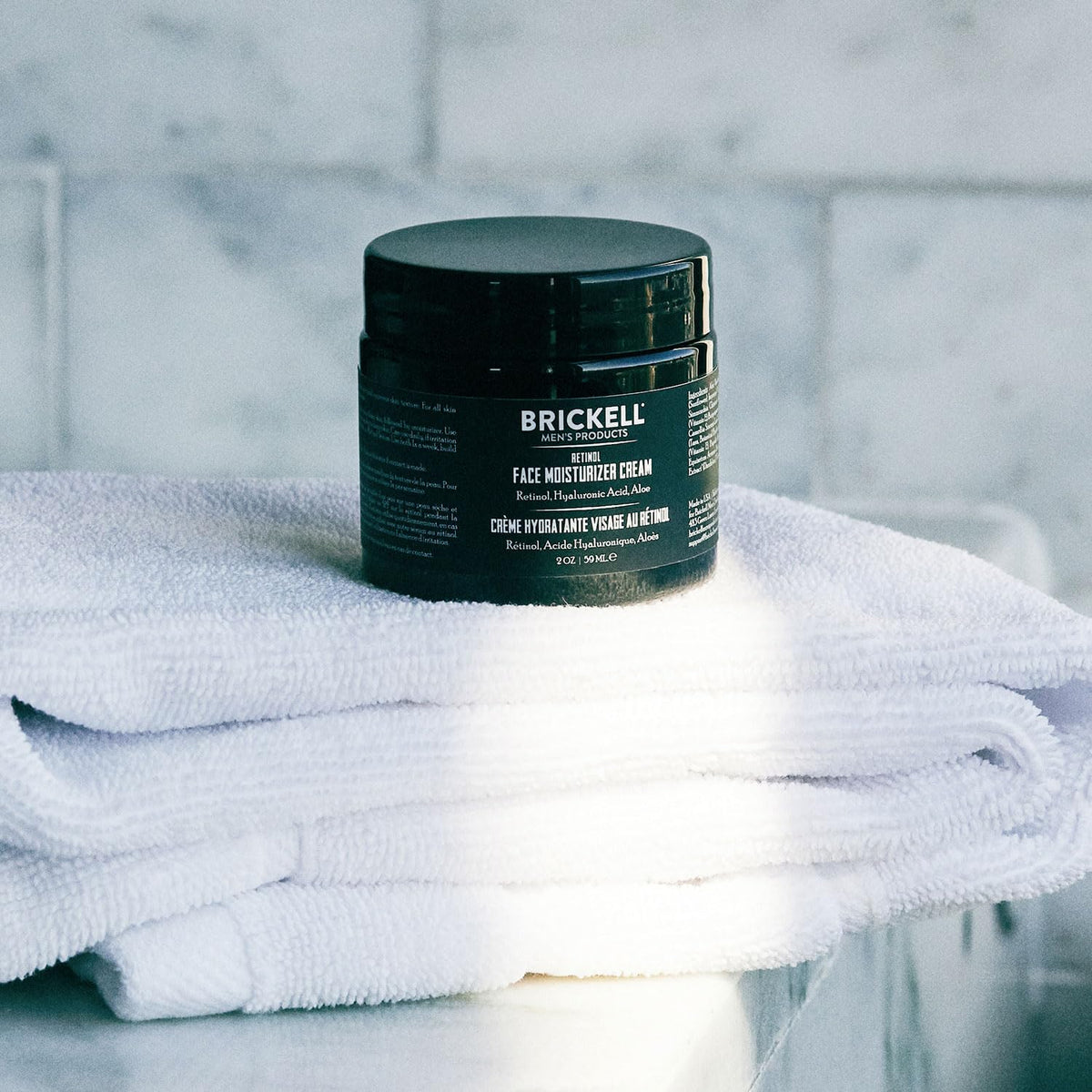 Brickell Men’s 2 oz tube next to razor showing compact travel-friendly size