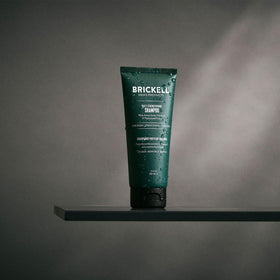 Brickell Men's Products bottle in hand under shower showing refreshing use benefit