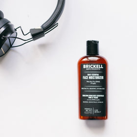 Brickell bottle next to everyday items showing compact 4 oz portability