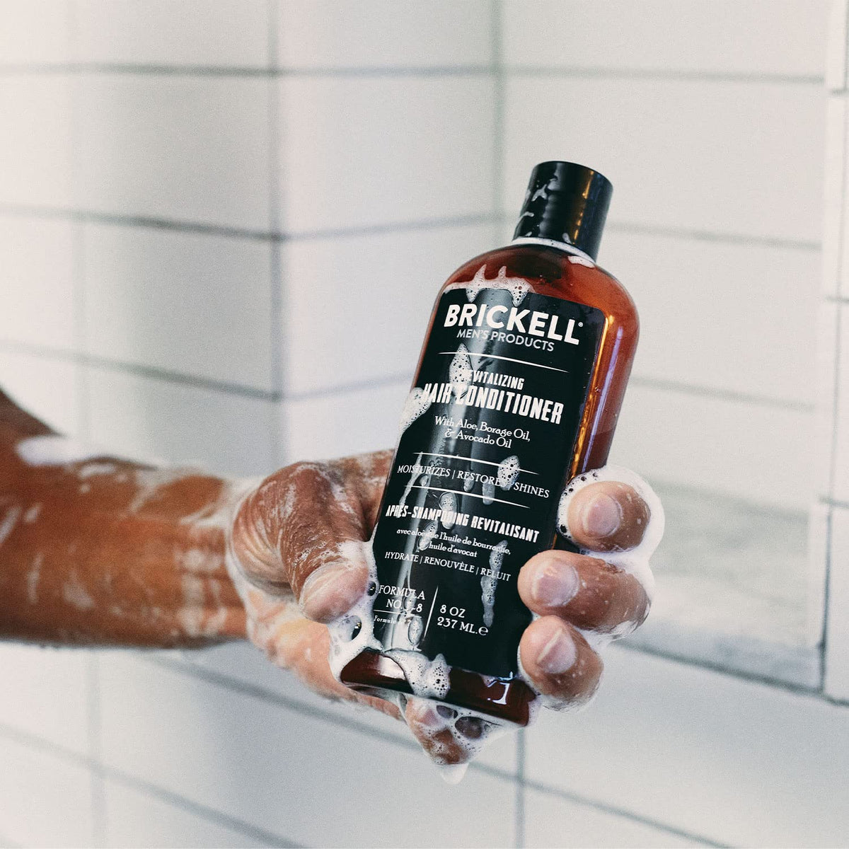 Brickell bottle next to a smartphone for size comparison, shows travel-friendly benefit