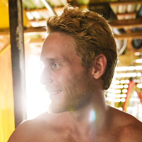 Brickell Men’s bottle on beach towel suggesting natural beach hair results