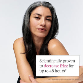 Model with curly hair using Briogeo spray to smooth frizz and enhance definition