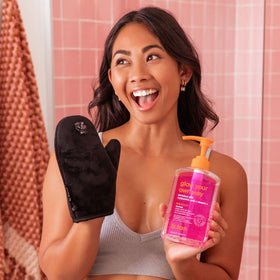 B.TAN bottle held in hand to show size and travel-friendly convenience