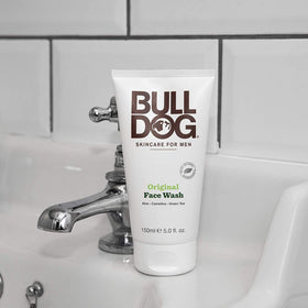 Bulldog tube beside hand for scale showing compact 5 oz size and portability