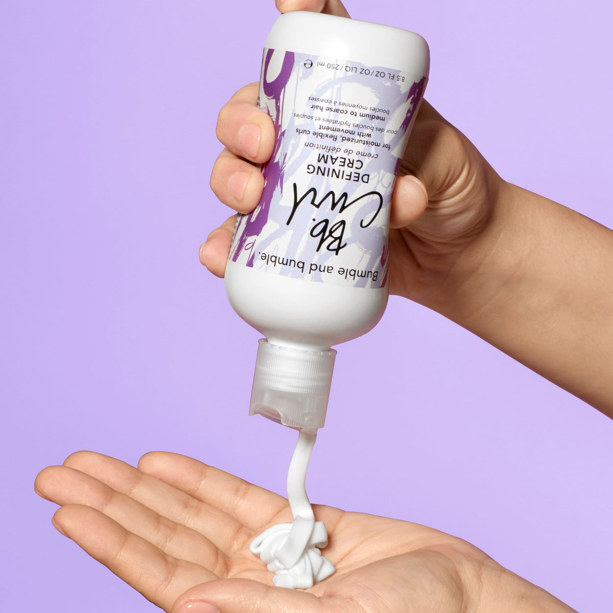 Bumble and bumble cream applied to curly hair for defined curl benefit
