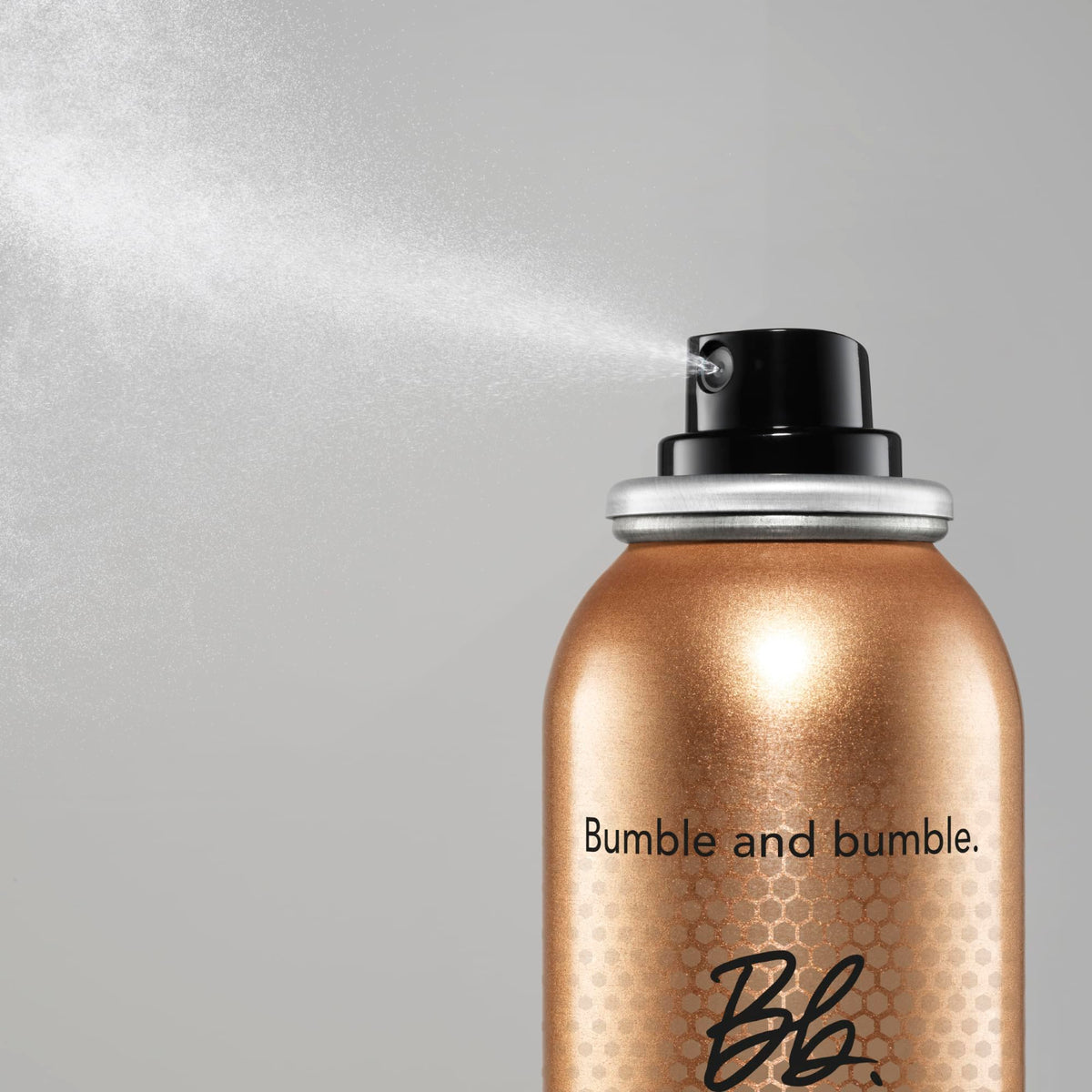 Bumble and bumble bottle in hand during blow-dry demonstrating faster styling