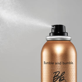 Bumble and bumble bottle in hand during blow-dry demonstrating faster styling