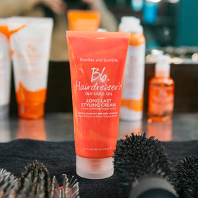 Bumble and bumble. bottle held in hand to display 6.7 fl oz scale and travel friendliness