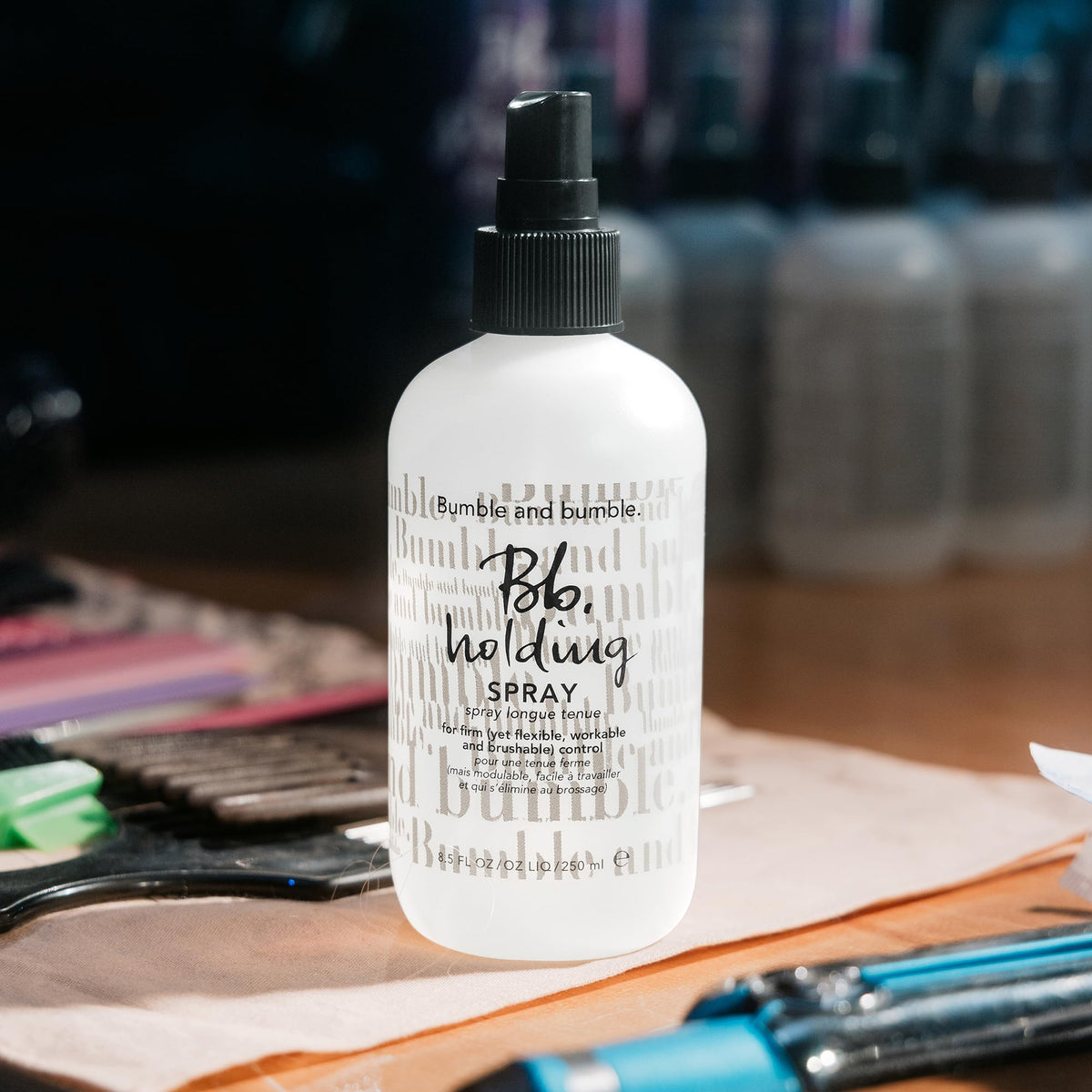 bumble and bumble held in hand to show 8.5 fl oz size and travel practicality