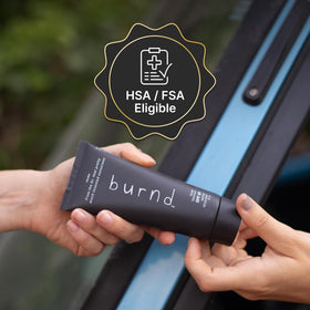 burnd placed with sunglasses on sand, brand suggesting beach and outdoor readiness