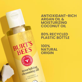 Burt's Bees bottle beside coconut and argan nuts indicating natural oils