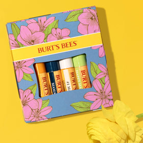 Burt's Bees Coconut & Pear tube beside fruit illustrating light fragrance benefit