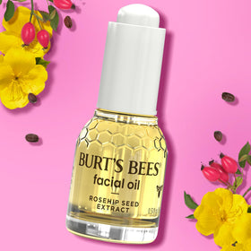 Burt's Bees oil next to a coin for size comparison showing travel-friendly benefit