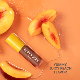 Burt's Bees lip oil next to lipstick to show compact size