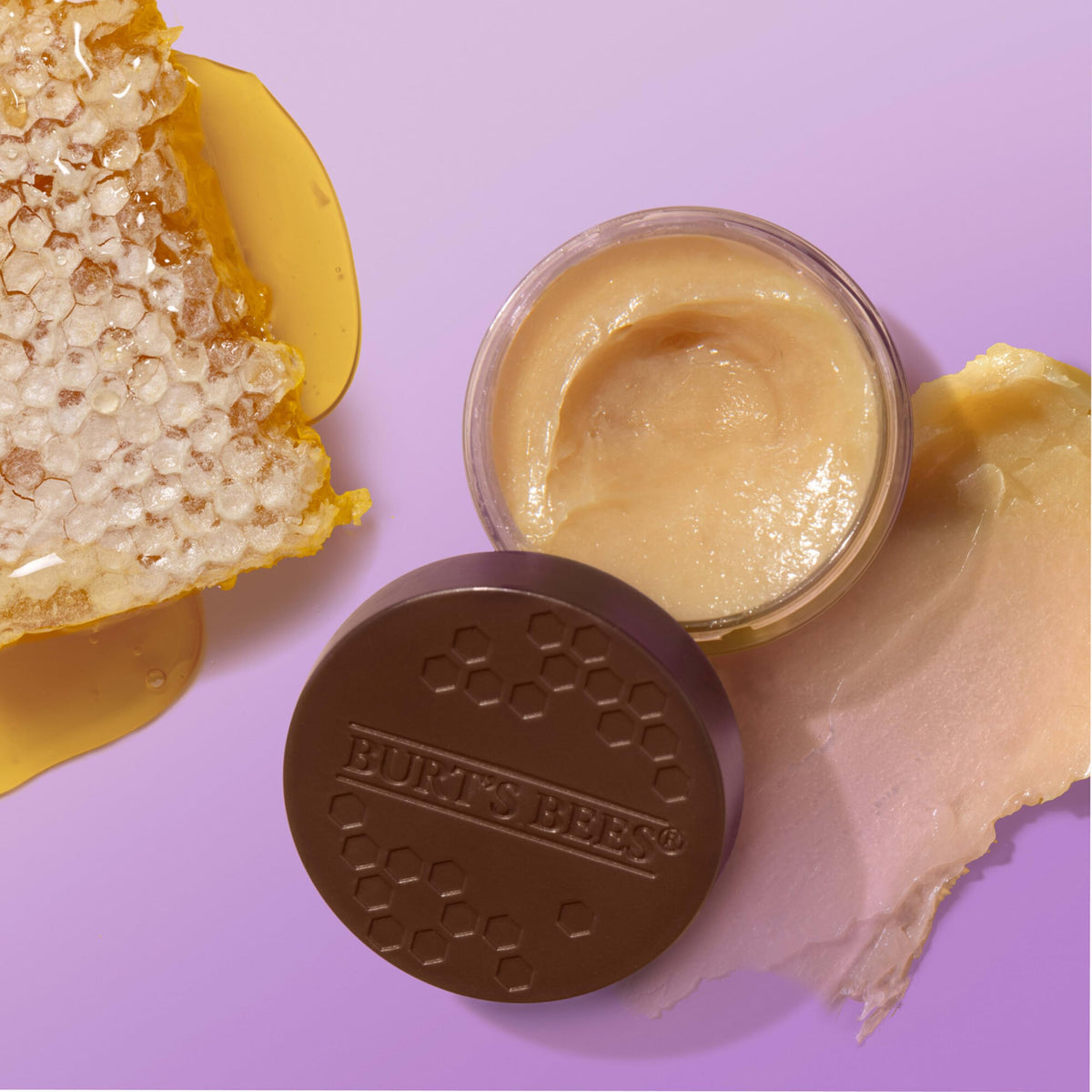 Burt's Bees jars held in hand to show compact, travel-friendly size benefit