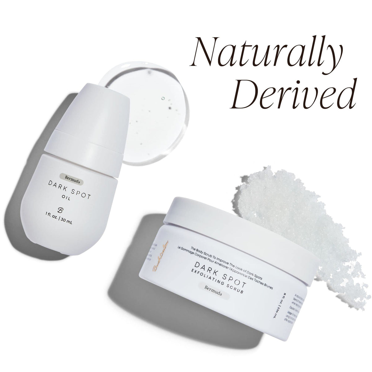 Bushbalm size comparison in hand conveying compact 30 ml oil and 236 ml scrub convenience