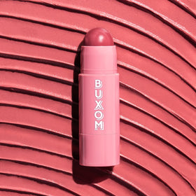 BUXOM Dolly Fever held in hand to show compact size and travel-friendly design