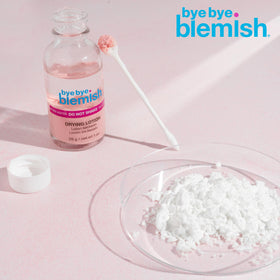 Bye Bye Blemish 1oz bottle next to coin to show small travel-friendly size