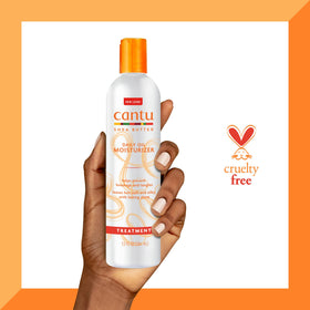 Cantu bottle next to a hand to show 13 fl oz scale and travel readiness