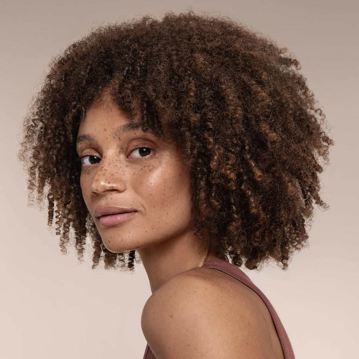 Cantu misting onto curl texture to show hydration and reduced frizz