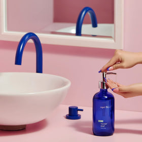 Capri Blue bottle shown next to a hand for size and ease-of-use benefit