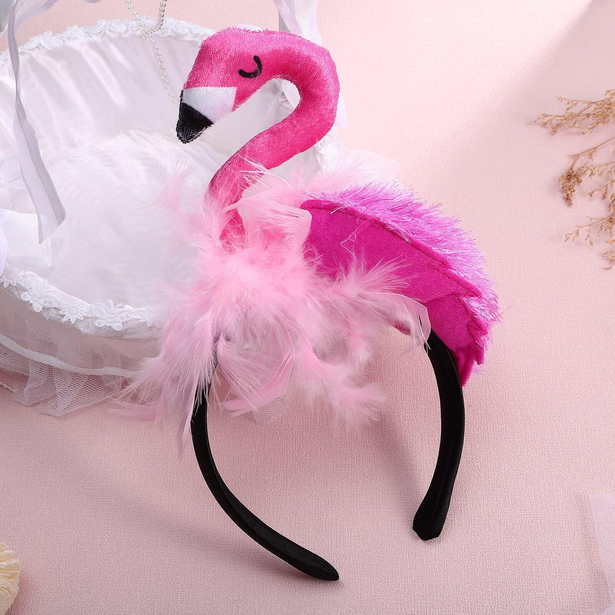 CARMELIT flamingo headband next to a hand for size comparison and wearable scale