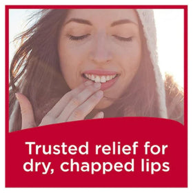 Carmex Fresh Cherry tube on a beach towel illustrating water-resistant outdoor benefit