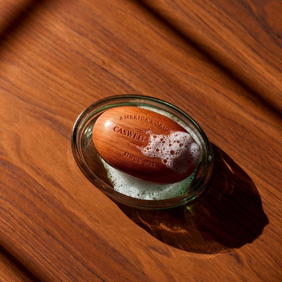 Hand creating creamy lather from Caswell-Massey soap, demonstrating rich foam and gentle cleansing benefit