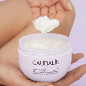 Caudalie body butter on bathroom vanity in lifestyle setting promoting routine use