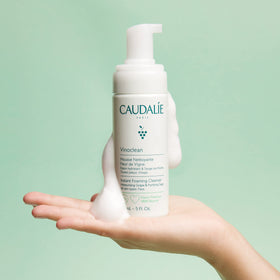 Caudalie foam texture on hand illustrating lightweight, gentle cleansing feel