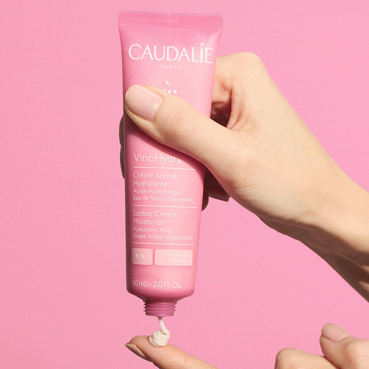 Caudalie 60 mL jar next to hand for true size and travel-friendly benefit