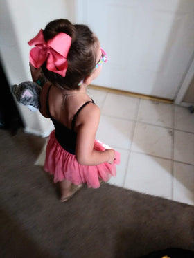 CÉLLOT child wearing a bow in a ponytail showing visible style