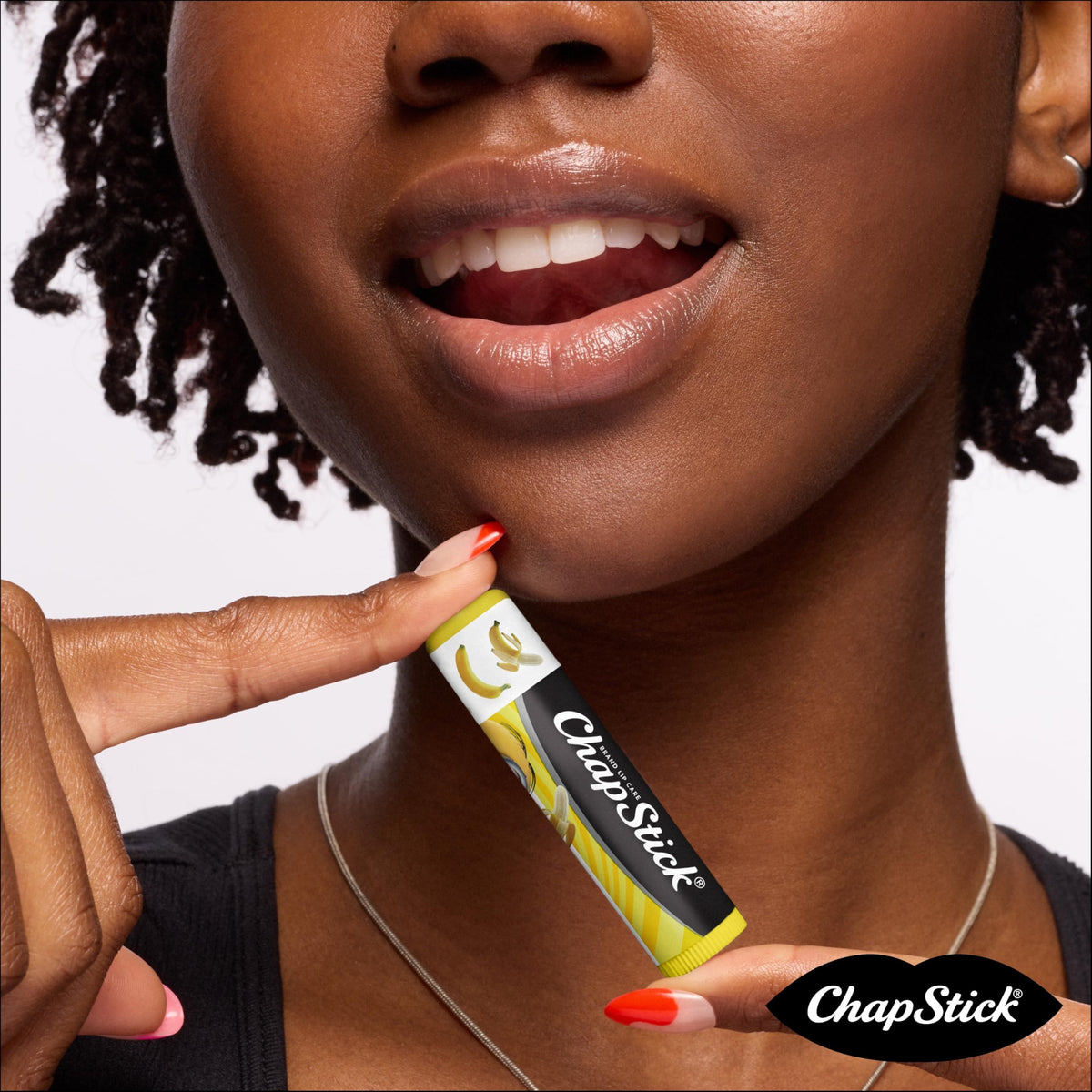 Child holding a ChapStick Minions stick smiling, showing portable convenience