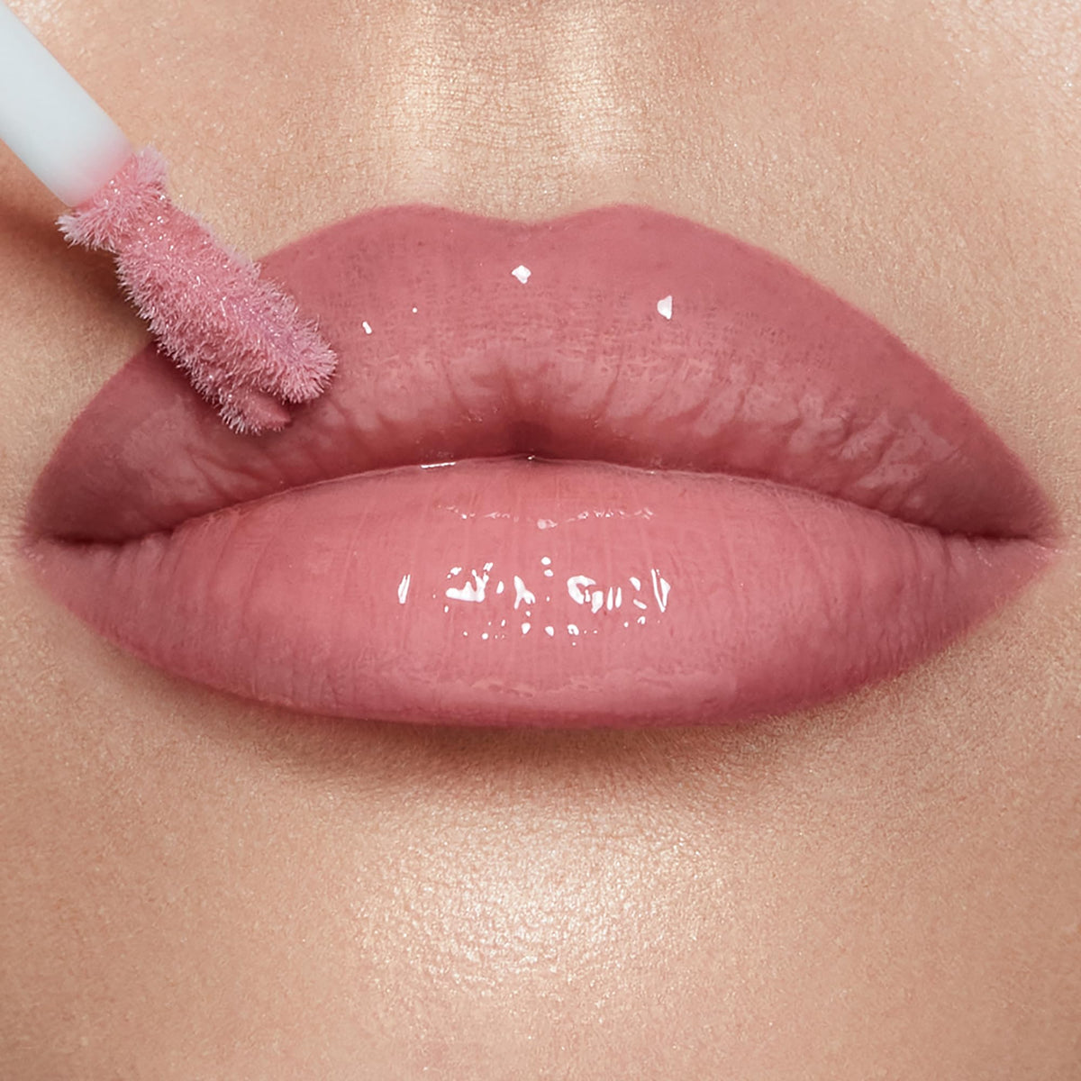 Charlotte Tilbury gloss worn by model closeup, shows cool-pink Pillow Talk Fair flattering glow