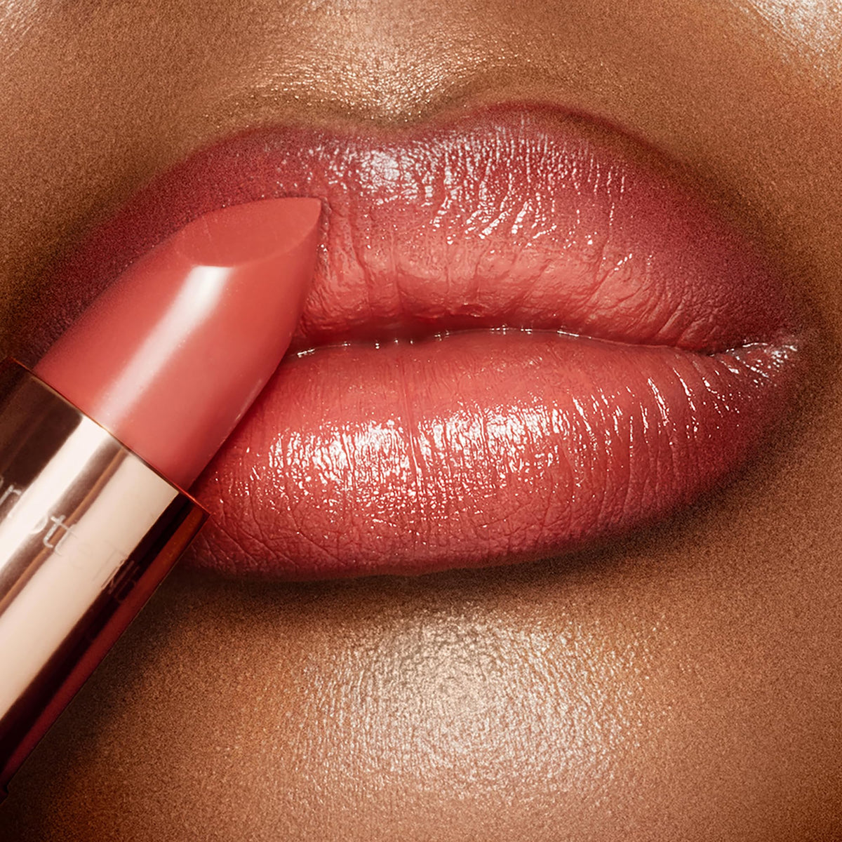 Charlotte Tilbury Coral Kiss worn by model highlighting warm coral tone and luminous, fuller-looking lips