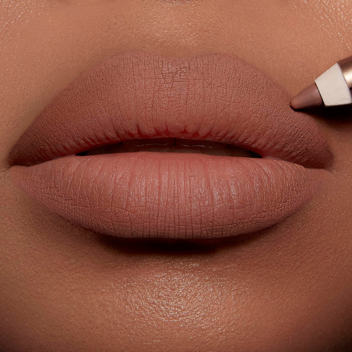 Charlotte Tilbury lip cheat applied on lips creating defined fuller-looking pout