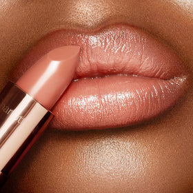 Charlotte Tilbury lipstick worn on lips illustrating natural nude-beige shade and fuller appearance benefit