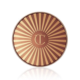 Charlotte Tilbury lifestyle image with model wearing beachy makeup for an everyday warm glow