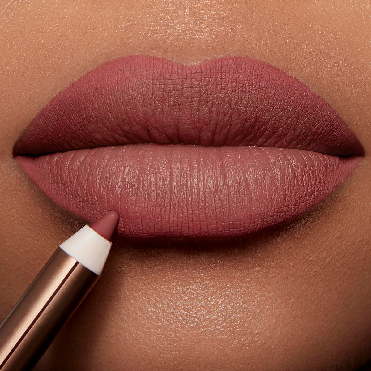 Charlotte Tilbury pencil in hand to show size and easy travel-friendly scale