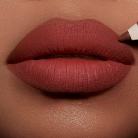 Charlotte Tilbury swatches on skin displaying warm caramel-red payoff for flattering color match