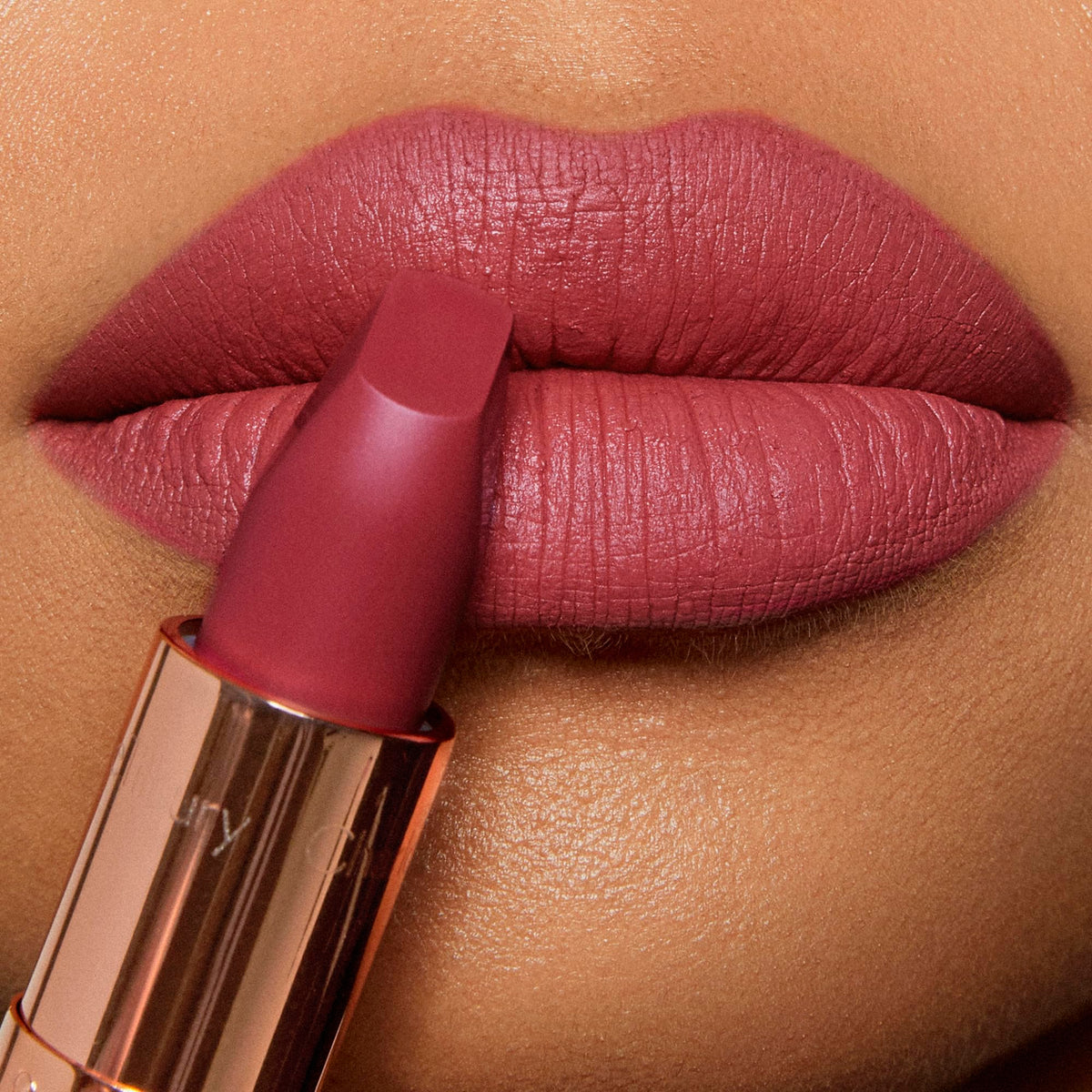 Charlotte Tilbury lipstick in use applying Gracefully Pink for flawless definition