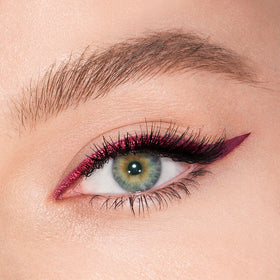 Texture swatch of Charlotte Tilbury Magic Eyeliner showing creamy maroon matte and shimmery violet metallic payoff