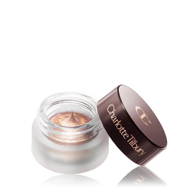 Charlotte Tilbury pot next to coin showing compact size for travel-friendly convenience