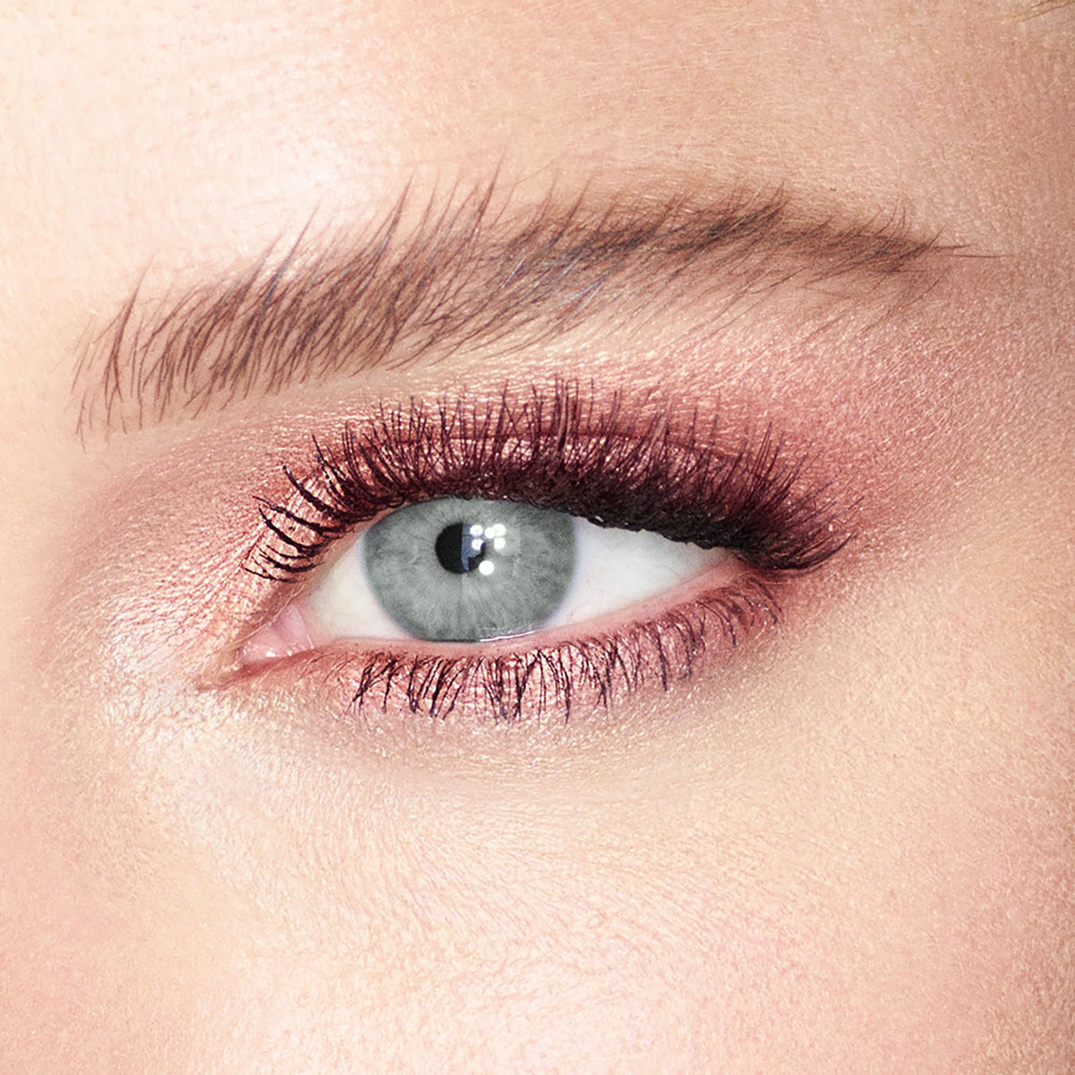 Charlotte Tilbury finger applying Rose Gold cream eyeshadow for easy blending