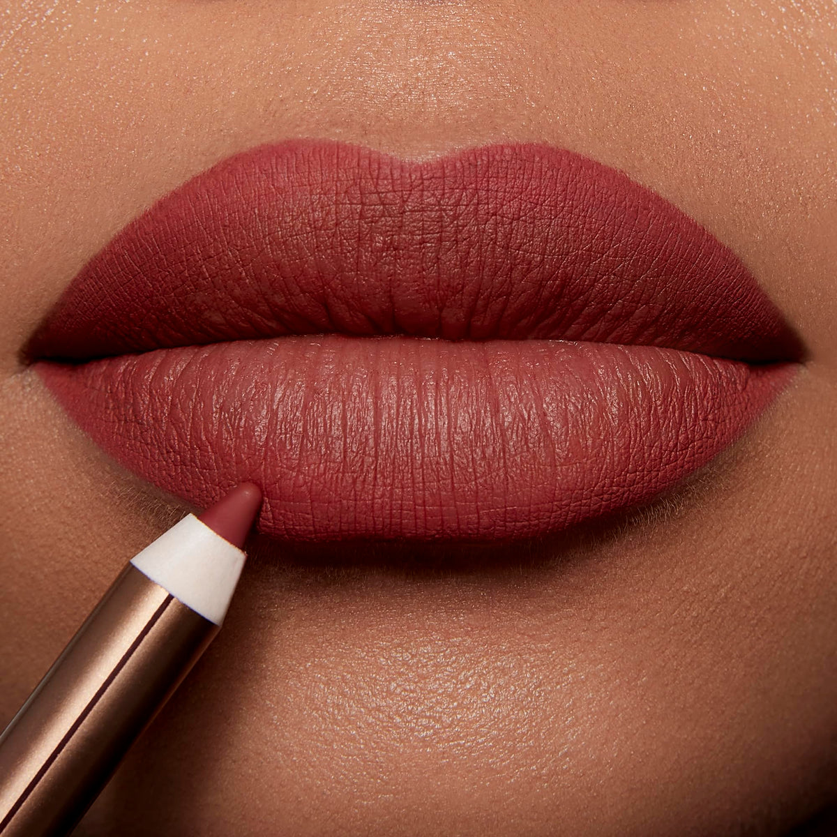 Charlotte Tilbury pencil held in hand demonstrating size and easy carry benefit