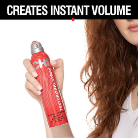 Hand spraying CHI texturizing hairspray showing lightweight mist for natural volume