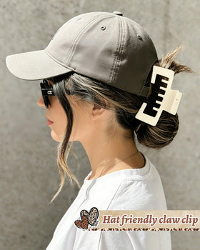 CHLINS clip holding a high ponytail while worn with a trucker hat