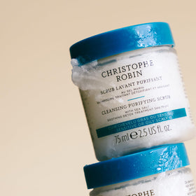 75ml Christophe Robin tube next to a hand to show compact travel-friendly size