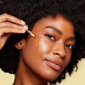 CLARINS hand applying oil to cheek to hydrate and soften skin quickly